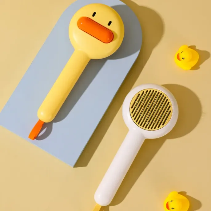 cat grooming comb (9) "Bright yellow pet grooming brush with duck design – a must-have for pet retailers, online shops, and grooming kits."