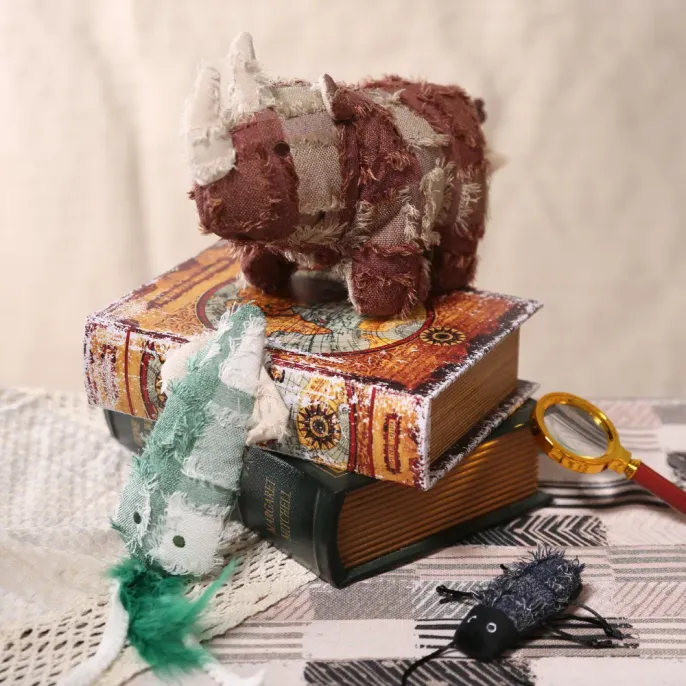 Hippie Series Plush Pet Toys Wholesale Collection A group of hippie style plush pet toys including a rhinoceros and a green chameleon on vintage books.