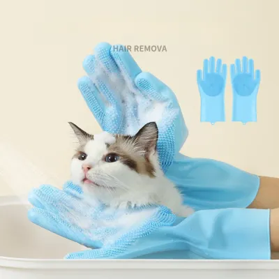 A close-up of a long-haired cat in a bath being massaged by foam-covered, light blue silicone grooming gloves.