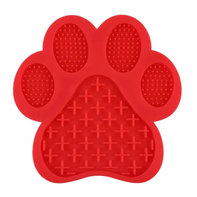 A vibrant red paw-shaped dog lick mat made of food-grade silicone with cross and dot textures for spreadable treats.