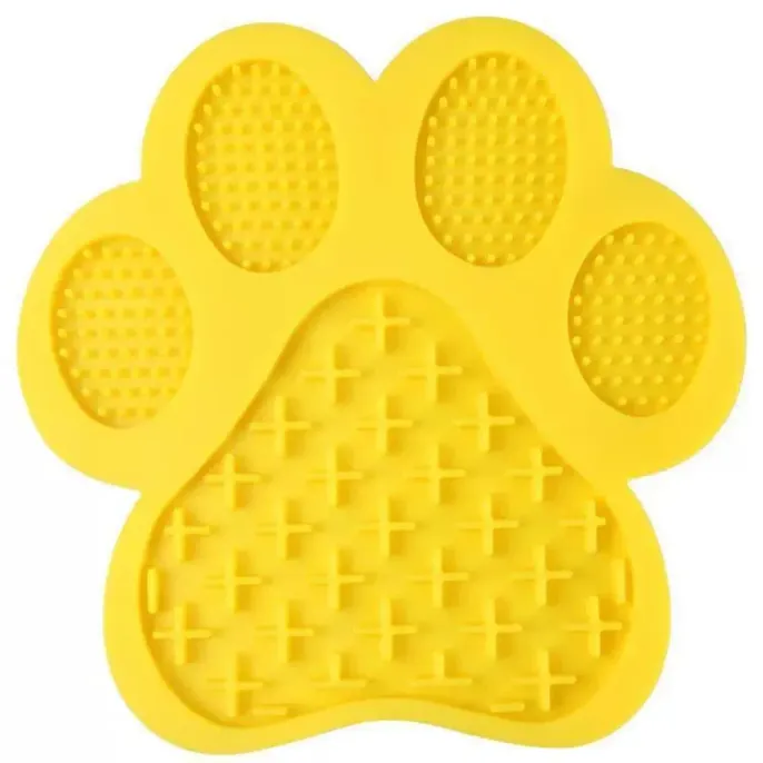 Top-down studio shot of a bright yellow paw-shaped lick mat featuring two different textures for treats.
