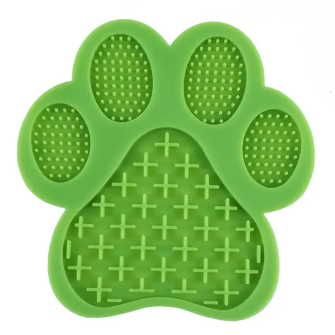 A close-up view of the green paw-shaped lick mat showing the "plus" sign and "dot" textures for spreadable treats.
