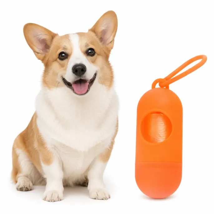 Corgi Puppy with Orange Dog Waste Bag Dispenser A happy Corgi dog sitting next to an orange pill-shaped pet waste bag dispenser on a white background.