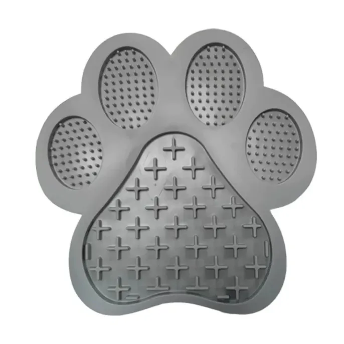 A modern grey paw-shaped lick mat for dogs, featuring a textured surface to promote dental health.