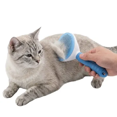 A hand using the pet grooming comb on a shorthair cat, showing the collected fur on the bristles.