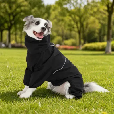 Black Reflective Dog Raincoat for Outdoor Use A happy dog wearing a black full-body waterproof raincoat sitting on green grass in a park.