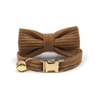 Close-up of a coffee-brown corduroy cat collar with matching bow tie and gold hardware.