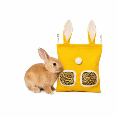 Rabbit Eating Hanging Hay Feeder Bag Yellow Bunny Foraging Toy Wholesale Petfairs Cute bunny eating hay from yellow hanging rabbit hay feeder bag interactive foraging toy for small pets