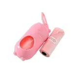 Close-up of the pastel pink bear-shaped pet waste bag dispenser with one pink refill roll showing a directional arrow.
