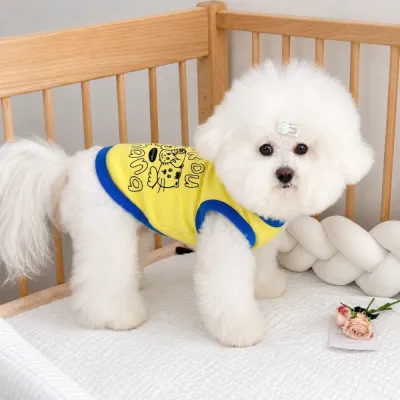Small White Dog Wearing Cartoon Pet Vest | Petfairs Small white dog wearing yellow cartoon print pet vest in indoor home setting