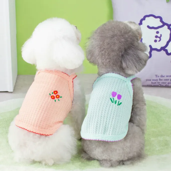 Dog Summer Vests with Floral Embroidery Back View Rear view of two small white and gray poodles wearing breathable pink and mint green mesh vests with embroidered flowers.