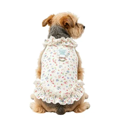 terrier-dog-wearing-floral-princess-dress-back-view A small terrier-mix dog from behind wearing a floral ruffled dress, showcasing the fit and the D-ring placement.