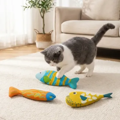 Indoor cat playing with colorful realistic fish cat toys on living room carpet