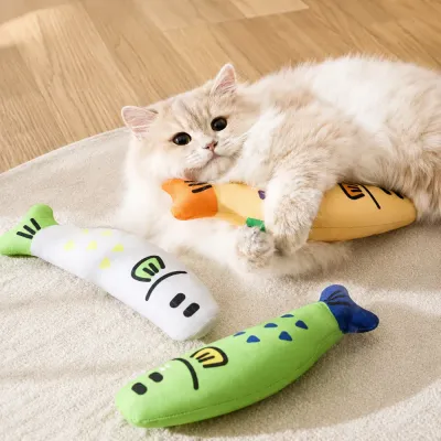 Indoor Cat Playing with Plush Fish Catnip Toy Fluffy indoor cat hugging and playing with soft cartoon fish catnip toys on carpet