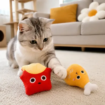 Cat Playing with French Fries and Drumstick Catnip Plush Toys Indoor cat playing with french fries and chicken drumstick catnip plush toys on living room carpet
