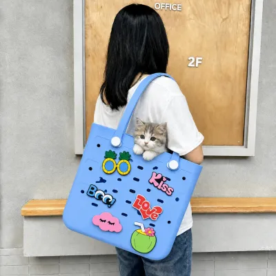 Blue EVA Pet Tote Bag Carrying a Small Puppy Outdoors Woman carrying a blue EVA pet tote bag with a small puppy and decorative charms