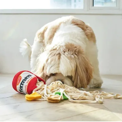 Dog Playing with Plush Ramen Noodle Snuffle Toy Fluffy dog sniffing plush ramen noodle forage toy with hidden treats on indoor floor