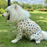 Large white dog wearing breathable summer mesh vest while relaxing outdoors on grass