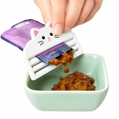 Cat Food Squeezer for Wet Food Pouches Cute cat-shaped cat food squeezer extracting wet cat food from a pouch into a feeding bowl