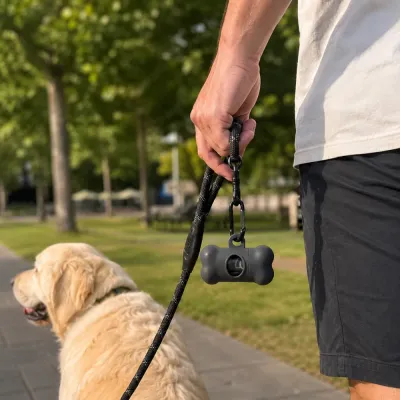dog poop bag dispenser attached to leash handle during outdoor dog walking with golden retriever