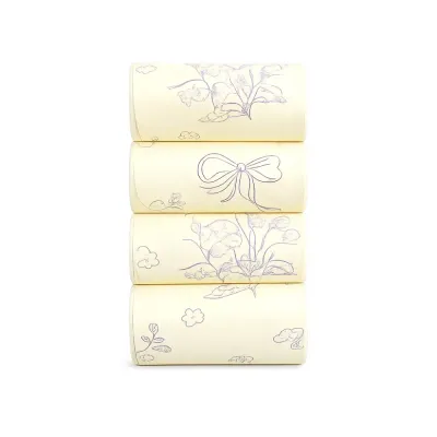 yellow-scented-pet-waste-bags-floral-print Close-up view of four rolls of light yellow scented dog poop bags decorated with purple flower and bow outlines.
