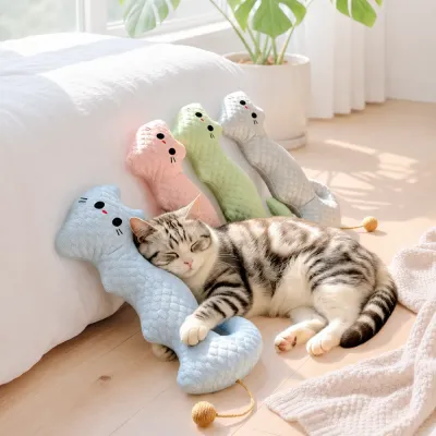 Cat sleeping beside blue cooling neck pillow toys in a bright indoor room