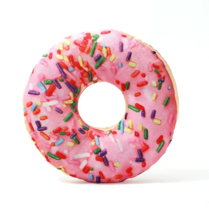 Pink donut plush dog toy with colorful sprinkles on white background