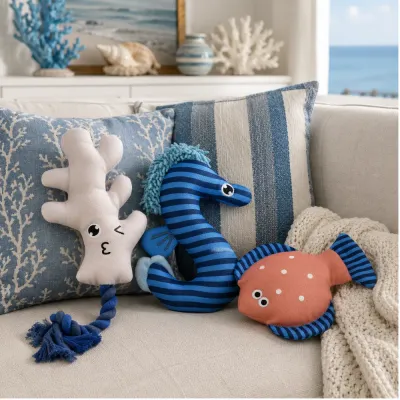 Summer nautical dog plush toys displayed on a coastal style sofa with blue and white home decor