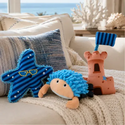 Summer nautical dog plush toys displayed on a coastal-style sofa with ocean-inspired home decor