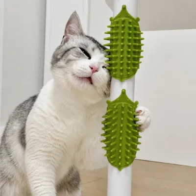 Cat rubbing its face on a green silicone self grooming brush attached to a post for daily grooming and massage