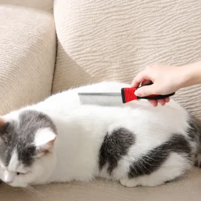 Long tooth cat comb being used to brush and groom a cat