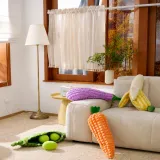 Banana plush dog toy with colorful vegetable plush toys in home setting