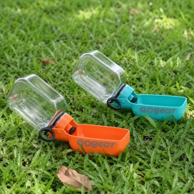 Two portable dog water bottles on grass with foldable drinking bowl, leak-proof travel pet water dispenser for outdoor walking and hiking.