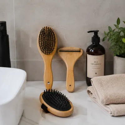 Bamboo Pet Grooming Tools in Bathroom Bamboo pet grooming brush set displayed beside pet shampoo and towels on a bathroom counter.