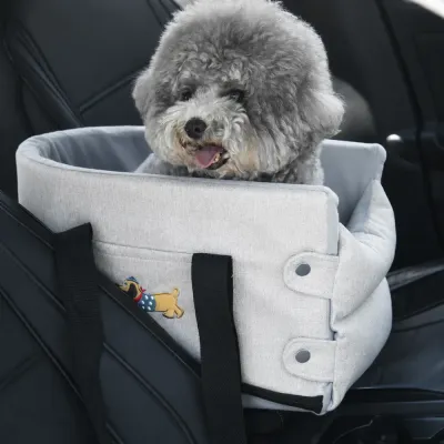 Khaki Dog Car Seat Carrier in Vehicle Gray curly-haired dog sitting in a padded khaki dog car seat carrier secured on a black vehicle seat.
