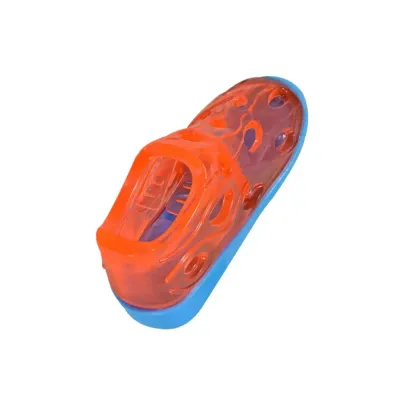 Transparent orange dog shoe treat dispensing toy with blue base on a white background