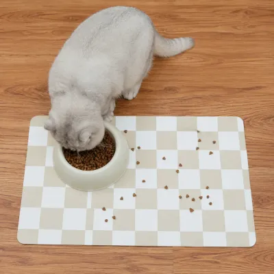 Waterproof Cat Feeding Mat for Food Bowls Gray cat eating from a bowl placed on a beige waterproof checkerboard feeding mat.