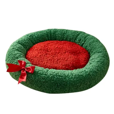 Plush Green and Red Christmas Cat Bed Plush green and red Christmas cat bed with raised sides and decorative red bow on a white background