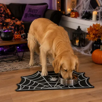 Dog Using Halloween Spider Web Feeding Mat Golden retriever eating from a bowl on a spider web pet feeding mat in a Halloween decorated living room