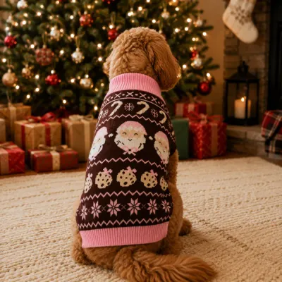 Dog Wearing Christmas Santa Sweater by Holiday Tree Dog wearing brown and pink Christmas sweater with Santa pattern beside decorated Christmas tree
