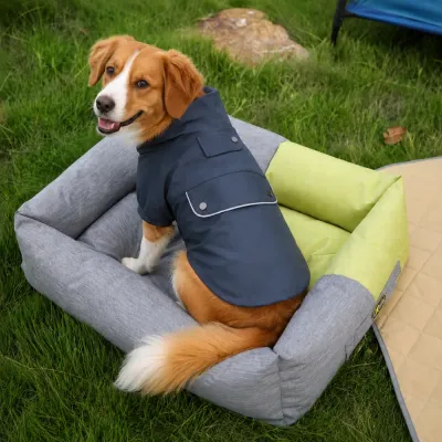 Water Resistant Dog Raincoat for Outdoor Adventures Dog wearing a navy water resistant PU raincoat outdoors while sitting on a pet bed