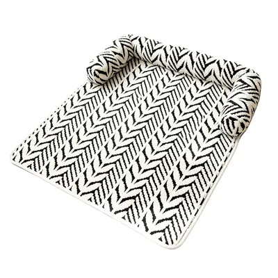 Plush striped pet bed mat with black and white pattern and raised side bolster