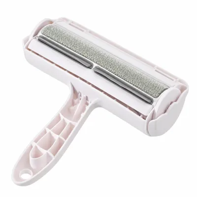 Light pink reusable pet hair remover roller with a textured cleaning surface, rotating roller head, ergonomic handle and hanging hole on a white background.